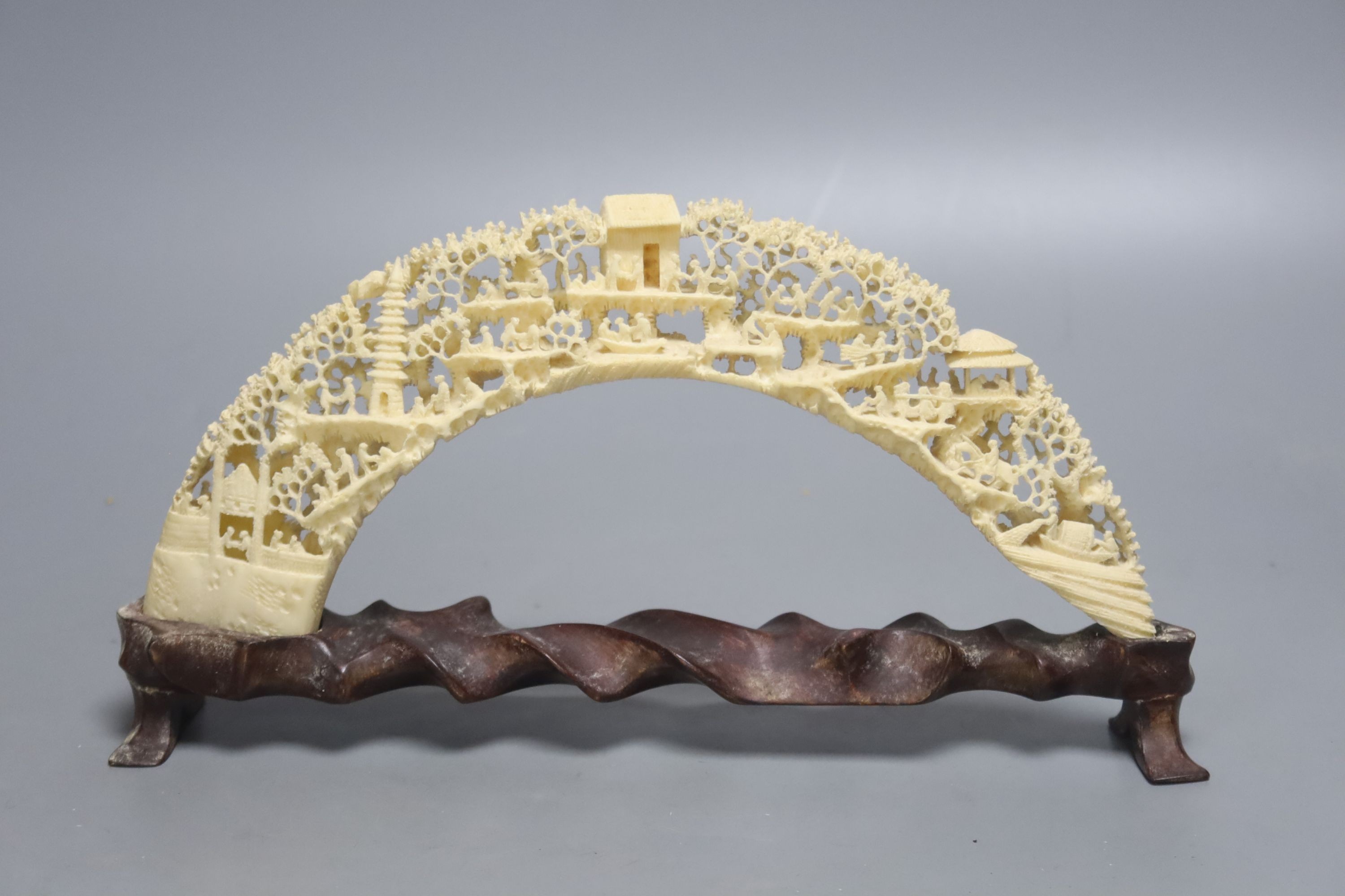 A 20th century Chinese carved and pierced boar’s tusk decorated with trees, 27cm wide